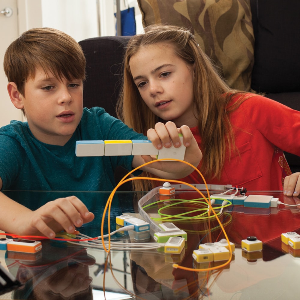Children holding coding blocks to build circuits