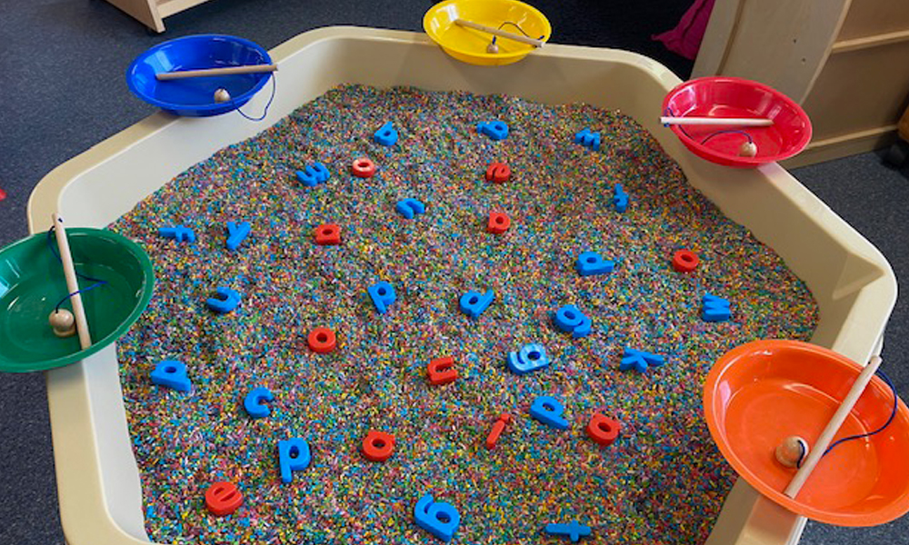 Hex Tray sorting activity featuring magnetic letters in coloured rice and magnetic fishing rods