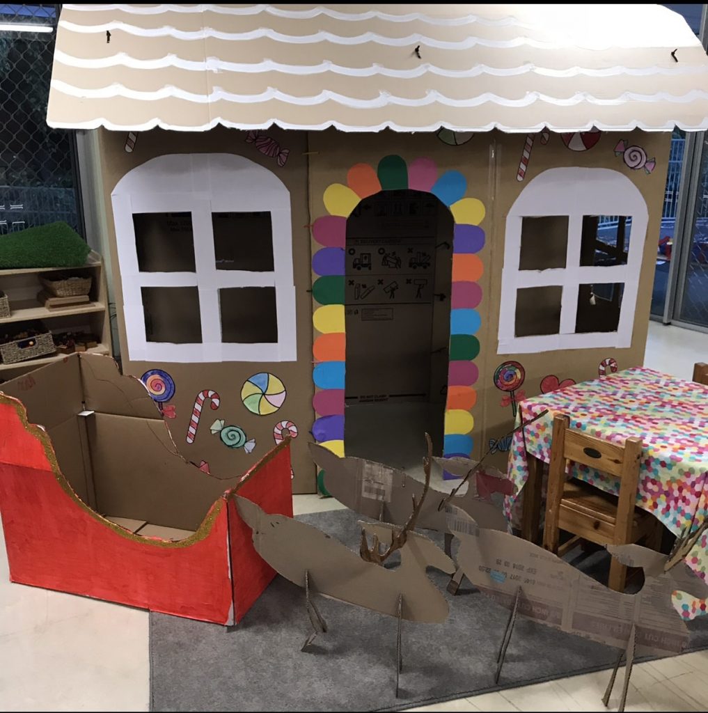 Christmas pretend play featuring cardboard craft house