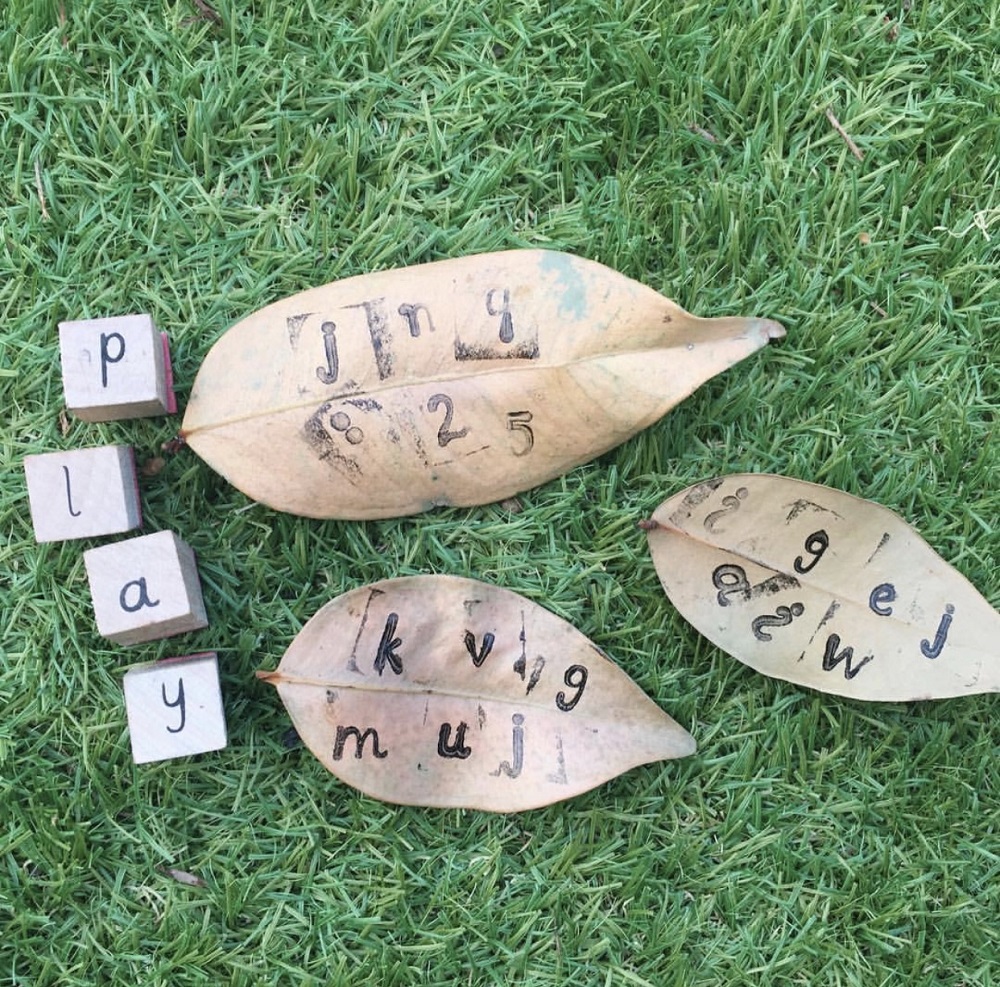 Alphabet cubed stamps are used to print letters on dried leaves