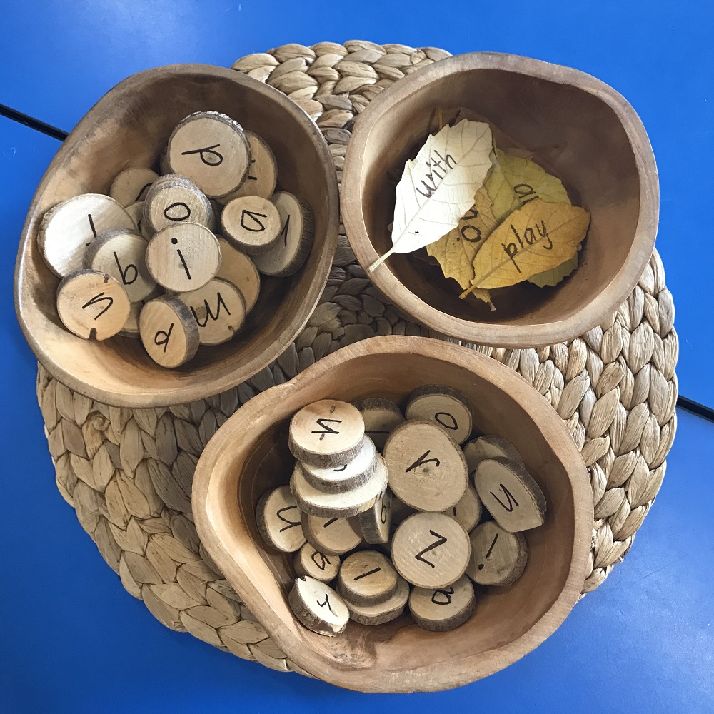 Letters written on wooden slices placed in wooden sorting bowls