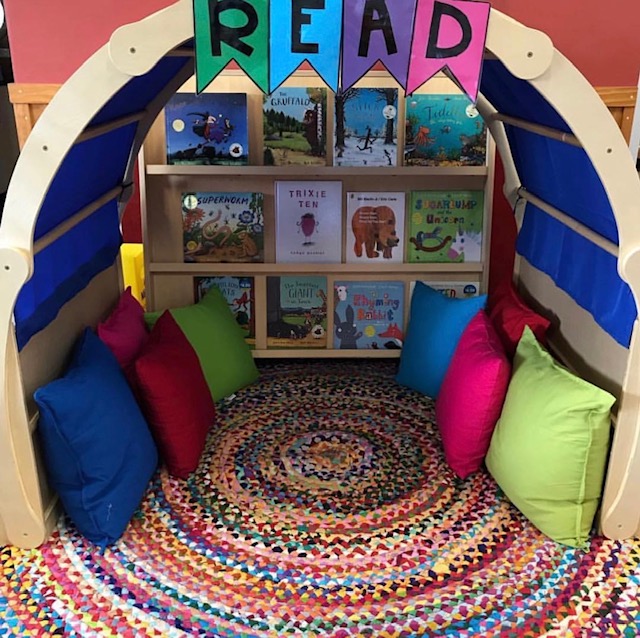 Reading corner featuring cushions books and reading arch