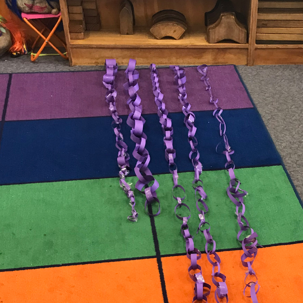 paper chains made of purple paper on coloured mat