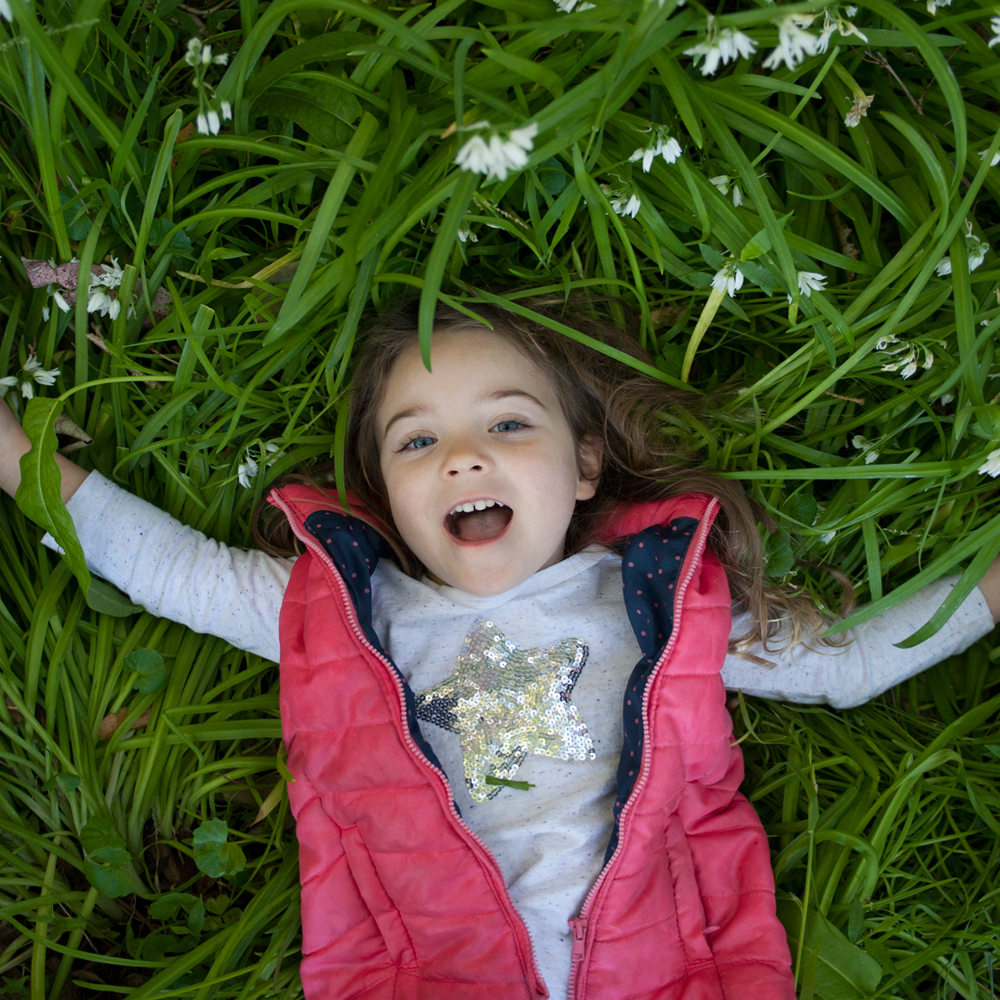 Young girl laying down on Grass