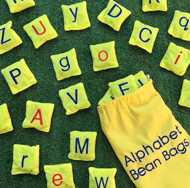 Alphabet bean bags on grass background
