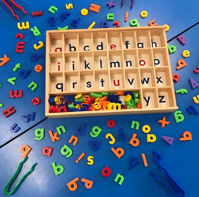 Alphabet sorting tray on desk with magnetic letters