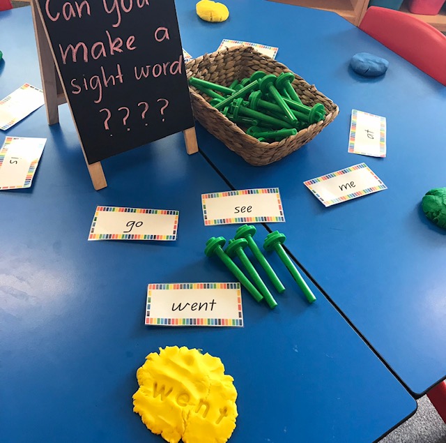 Lowercase alphabet dough stampers activity featuring blackboard on desk prompting students to make a sight word with the dough and stampers