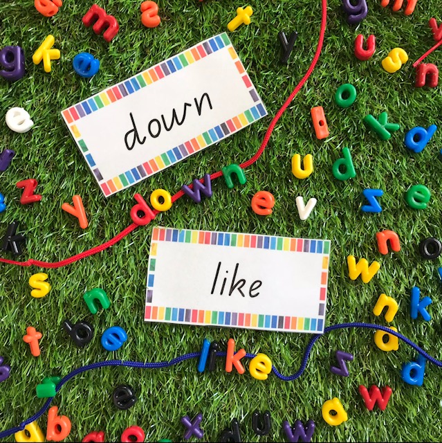 Lowercase letter beads threading activity on grass background