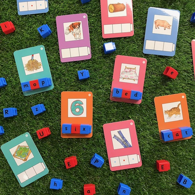 Phonic cvc matching activity featuring alphabet blocks and  CVC prompt cards on a grass background