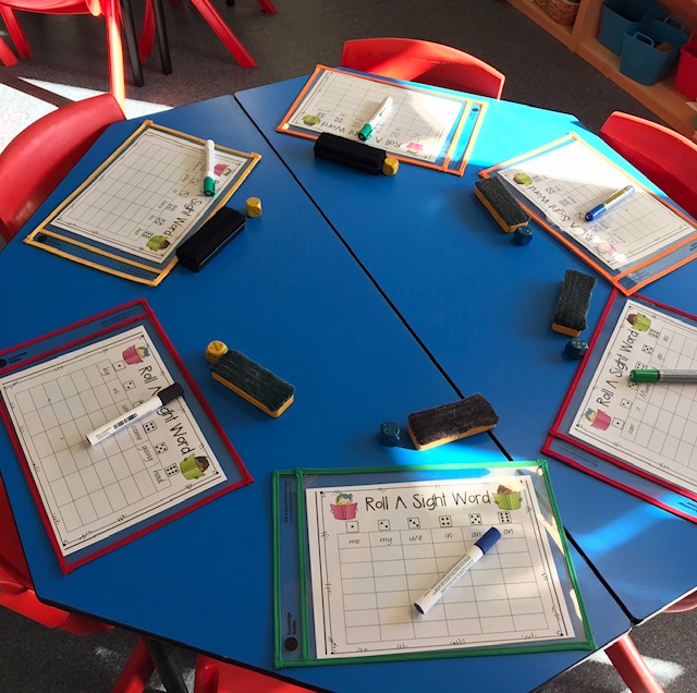 Write and wipe sleeves activity featuring whiteboard pens and markers on classroom desk