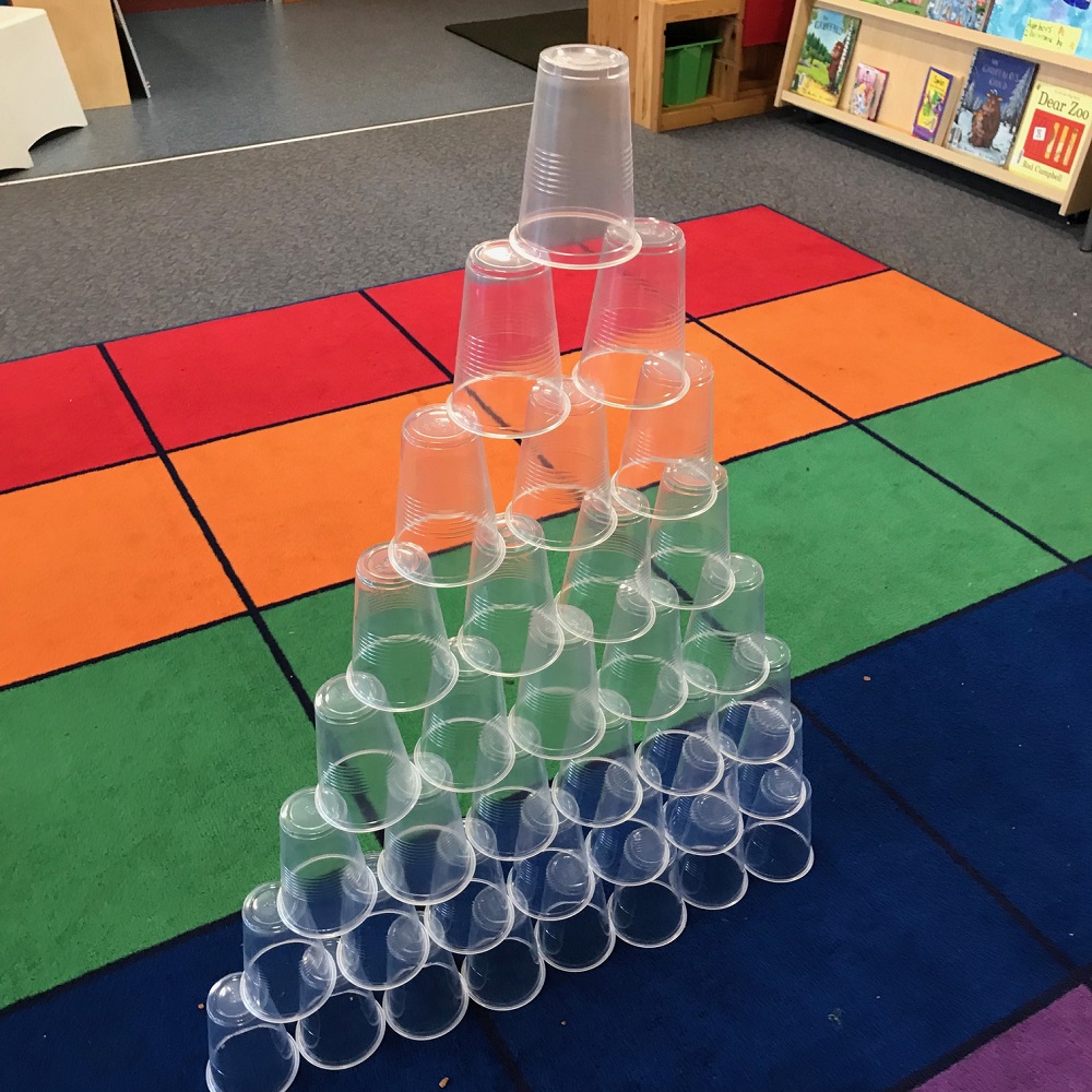 Plastic cups grouped together to form a pyramid tower