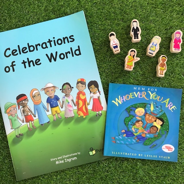 Celebrations of the world book with wooden figures on grass background