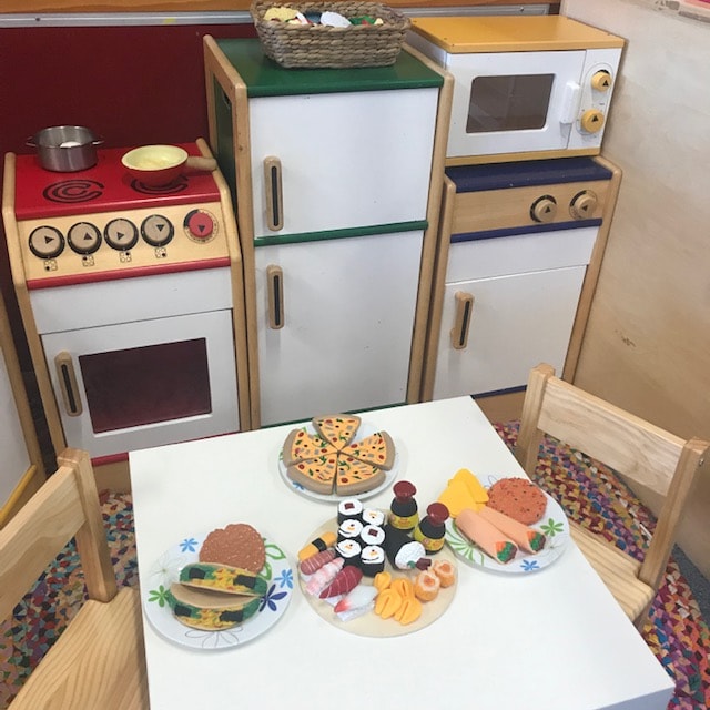 Home corner play space featuring kitchen and dining table