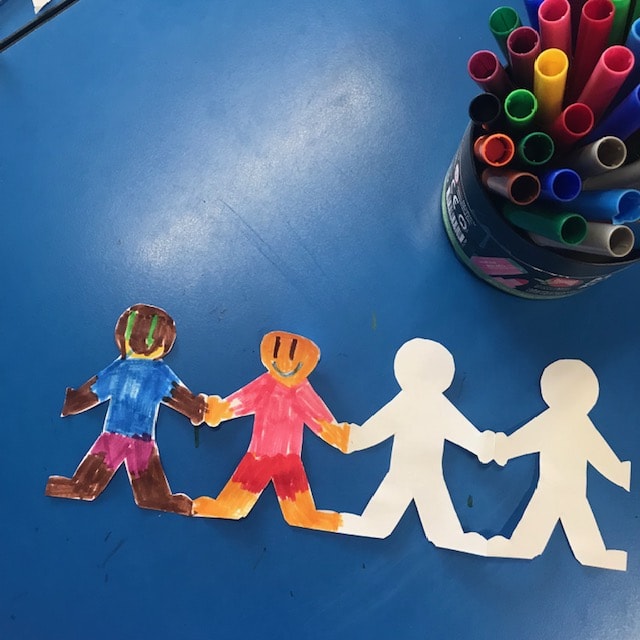 Paper chain dolls on classroom desk