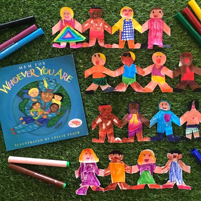 Paperchain dolls whoever you are book with coloured pens on grass background