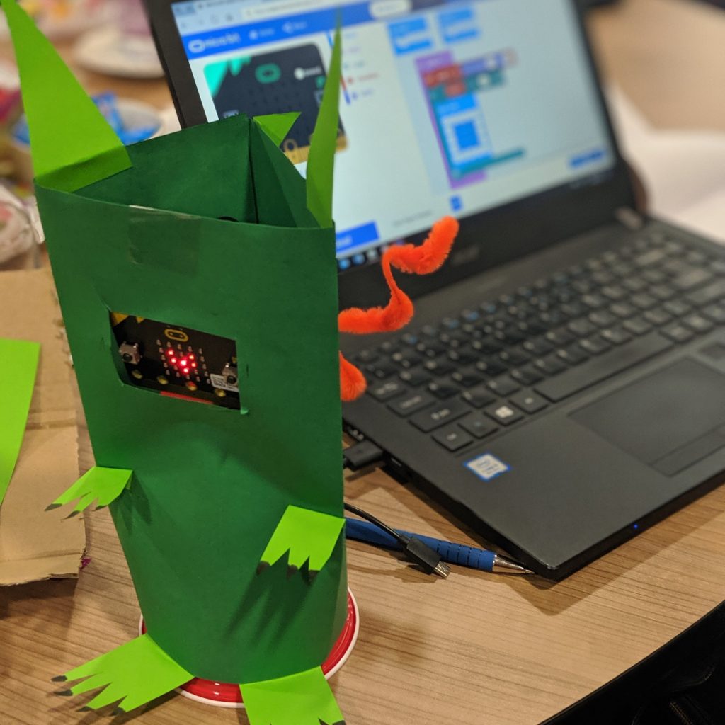 microbit pet green, faeturing laptop in background