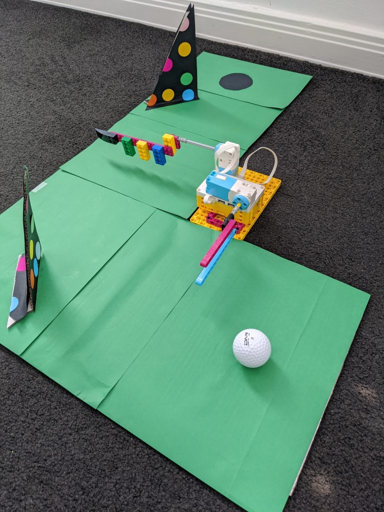LEGO Spike Golf Course featuring Spike model grean card and golf ball on floor