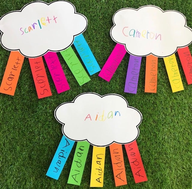 Rainbow names activity featuring clouds cut out of card with matching colourful name tags 