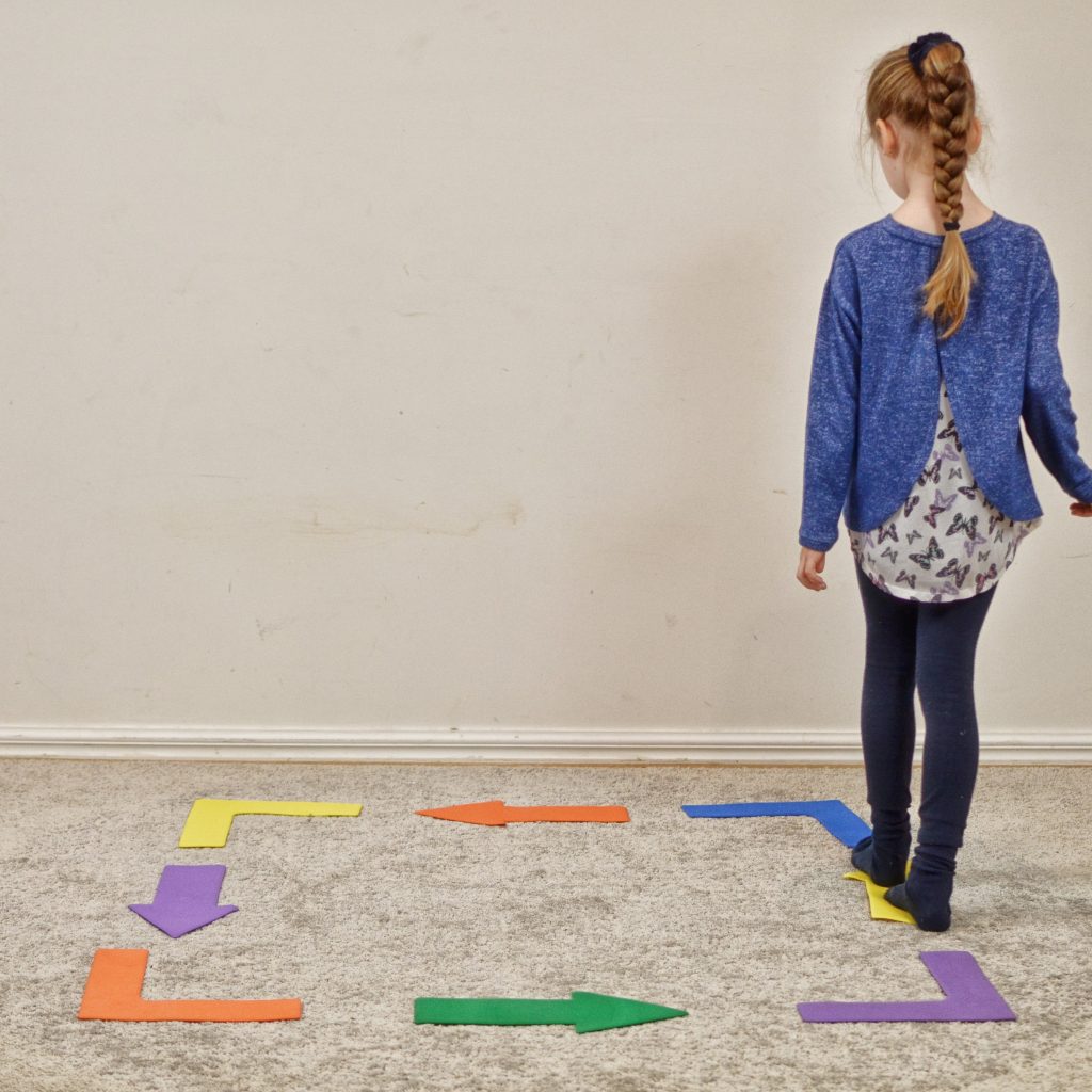 Staying Active at Home. Girl walking heel toe along arrows on floor