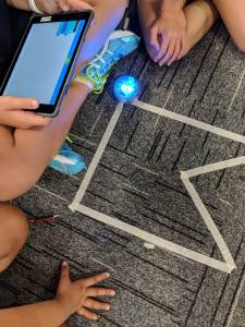 Sphero Angles and Shapes activity. Track on floor students holding tablet