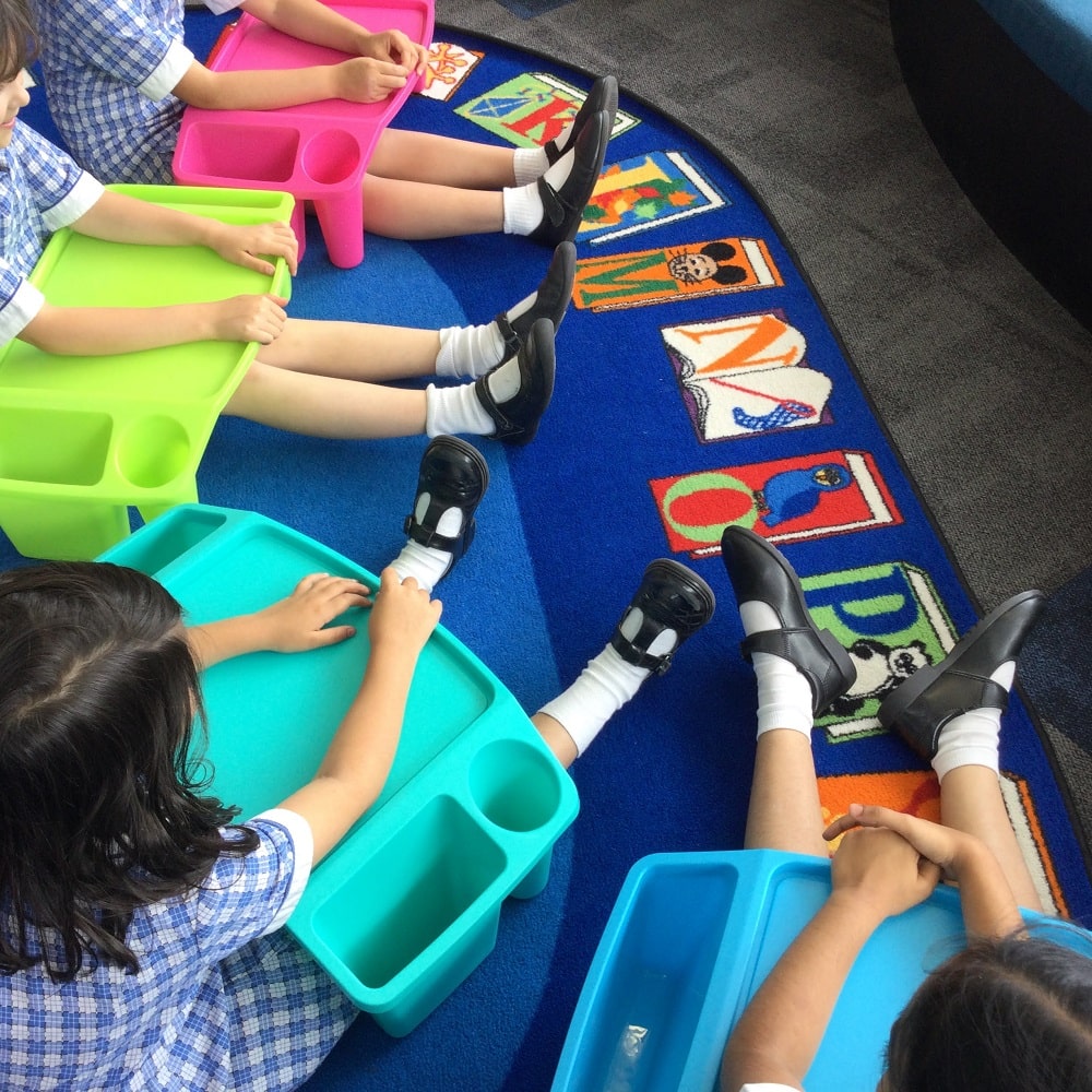 Children with Laptrays sitting on floor