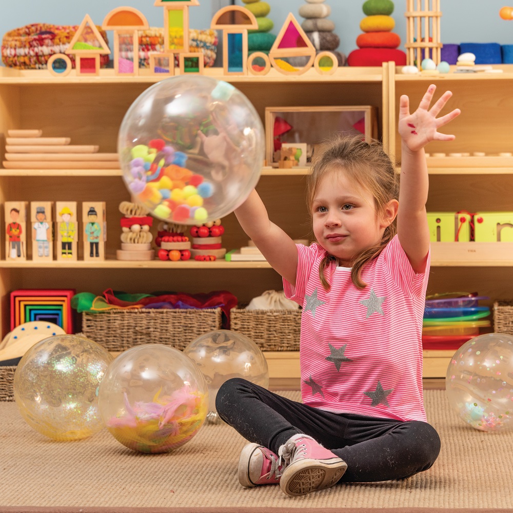 child playing with sensory balls in classroom