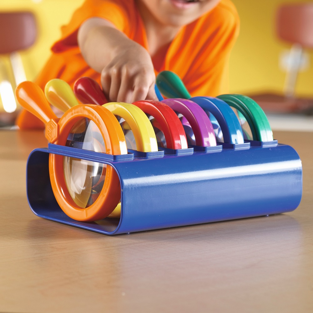 child reaching for jumbo magnifier off stand