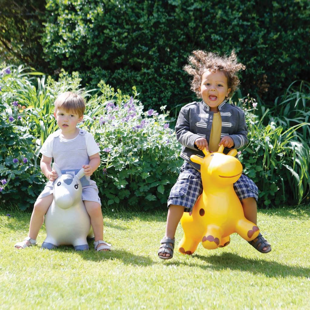 2 kids playing on Happy Hoppez in garden