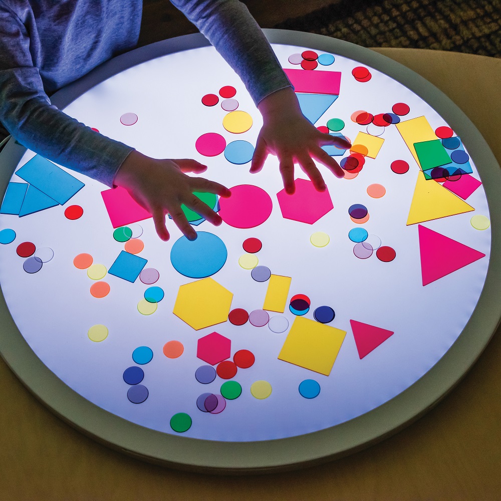 MTA Light table with chids hands and coloured shapes on top