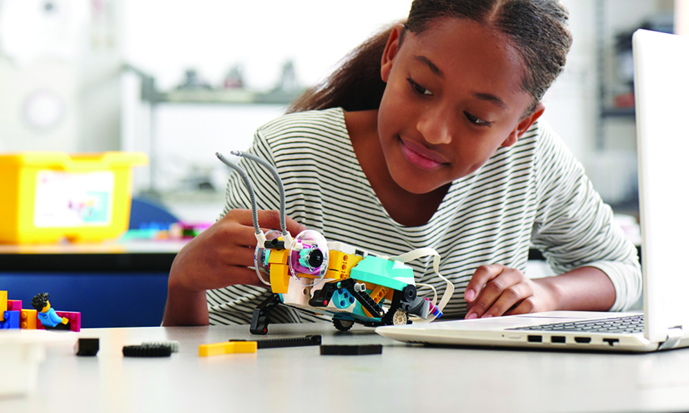 Girl building Lego Education Robotics model in classroom