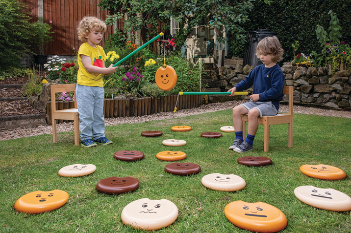 Children playing with magnetic fishing game in garden