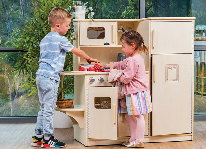 Children playing with wooden kitchen