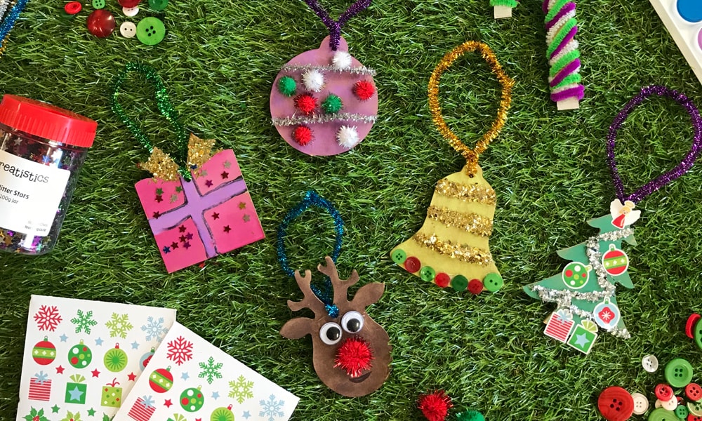 Christmas decorations spread featuring ornements and christmas stickers on grass background