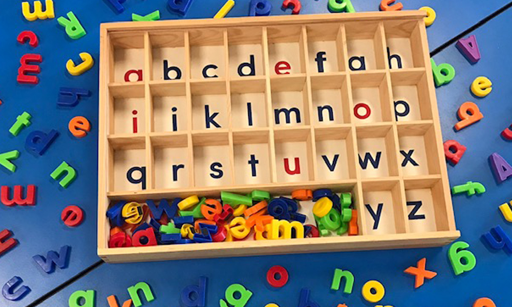Alphabet Sorting Tray And Magnetic Letters On Blue Desktop